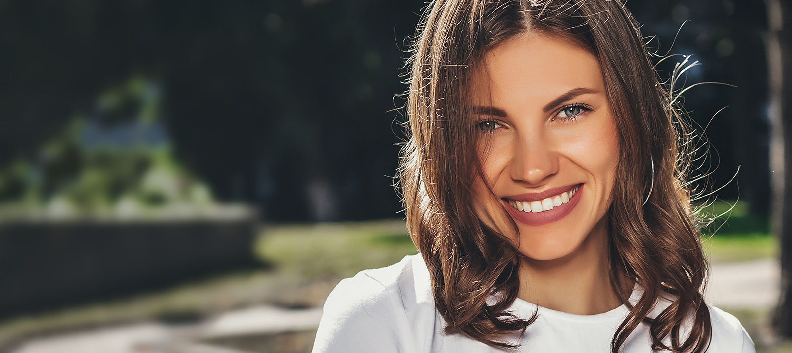 A woman with long hair and a smile, posing for the camera.